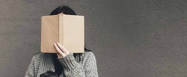 cropped view of woman in sweater holding book and coffee to go Biblioteket: Bogcaféer med nye bøger