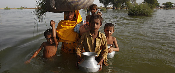 A family displaced by flooding wades through floodwaters is pictured as they return to their village of Bello Patan, in Pakistan's Sindh province in this September 21, 2010 file photo. A new plan to curb global warming risks becoming a battleground between rich and poor nations and could struggle to get off the ground as negotiators battle over the fate of the ailing Kyoto climate pact. To match Analysis CLIMATE-DEAL/ REUTERS/Akhtar Soomro/Files (PAKISTAN - Tags: ENVIRONMENT POLITICS) Hjælp de lokale sogne med at gøre verden mere klimaklar